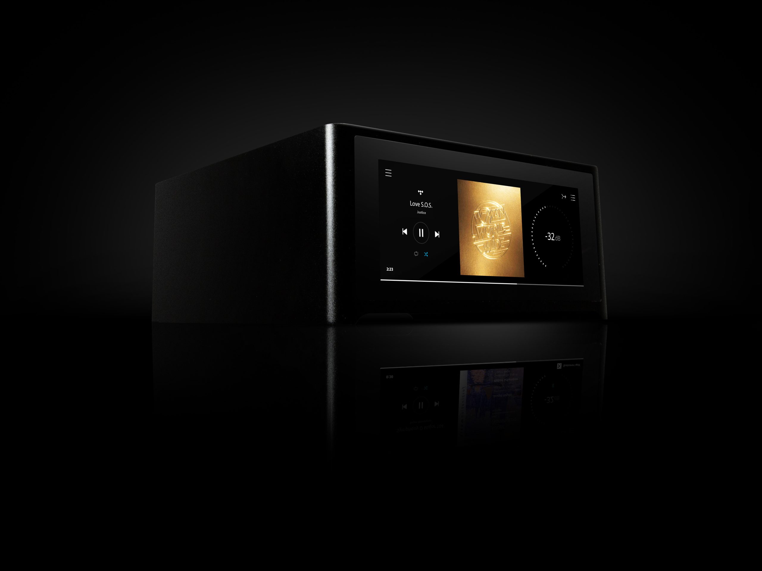 Studio photo of a compact black NAD M10 V3 streaming amplifier; its illuminated color touchscreen shows album art and volume level, reflected on a glossy black surface.