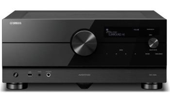 Front view of a sleek black Yamaha Aventage home-theater A/V receiver with large central volume knob and digital readout.