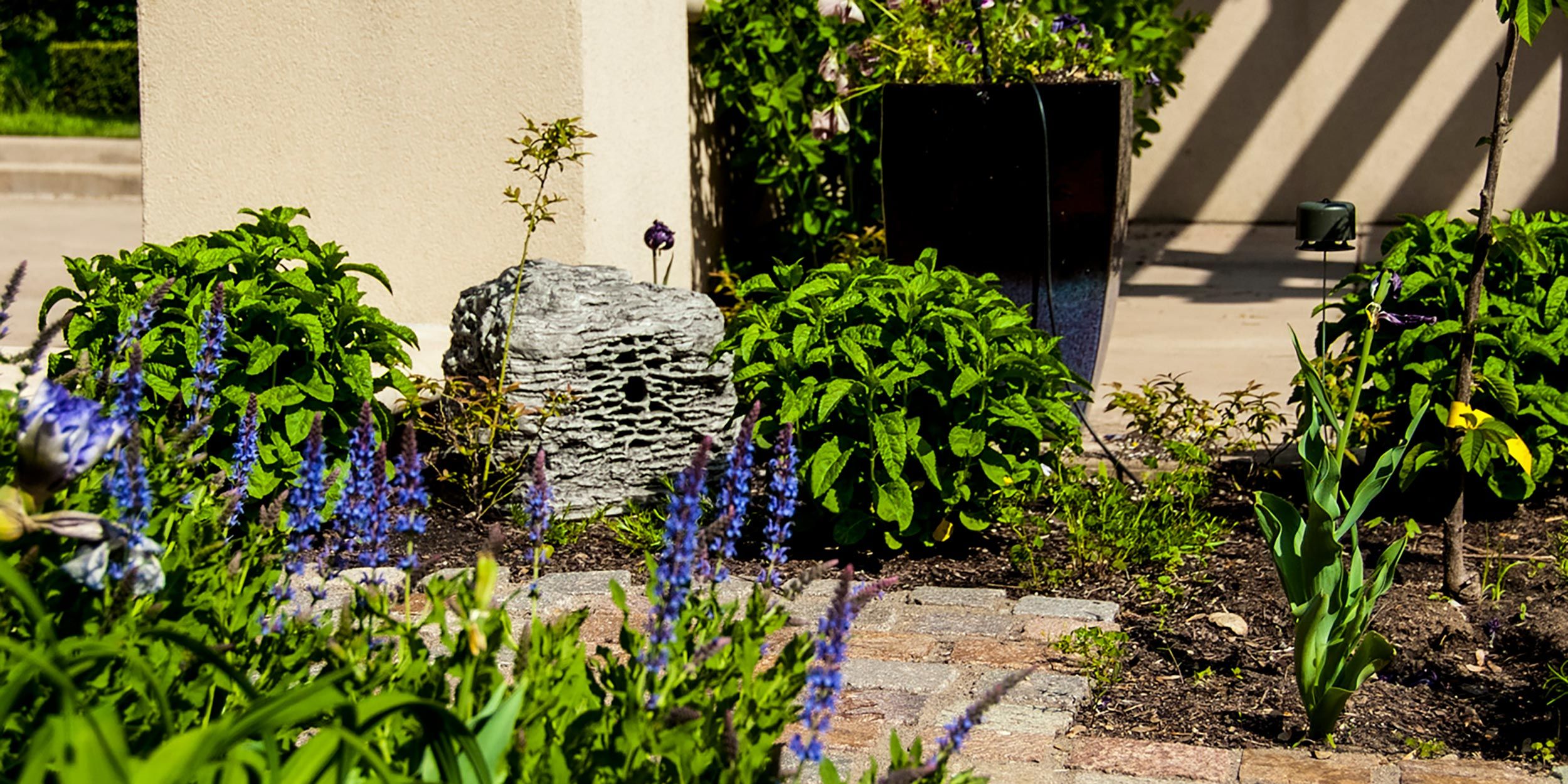 A garden scene showcasing outdoor speakers integrated seamlessly with landscaping.